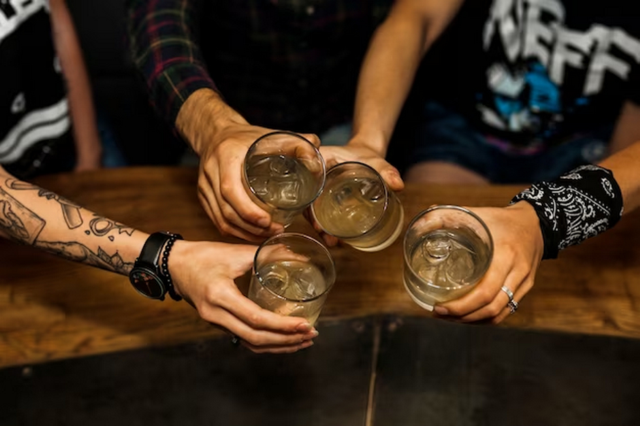 photo overhead view of friends holding glass of cocktails