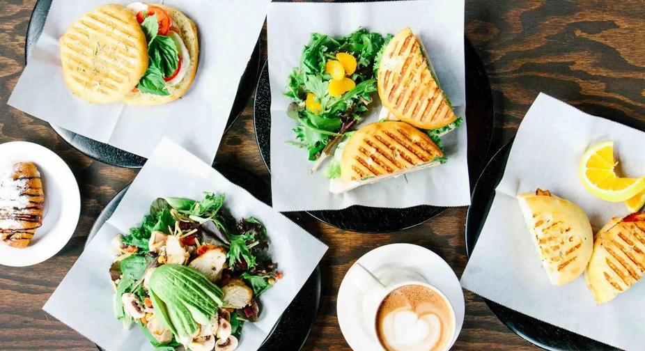 Sandwiches, salad and coffee on the table, top view