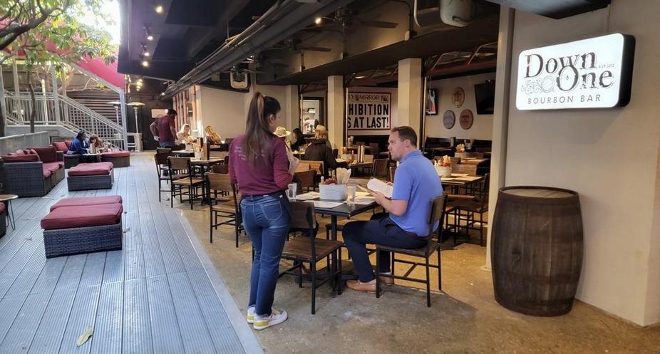 A girl takes an order from a bar visitor