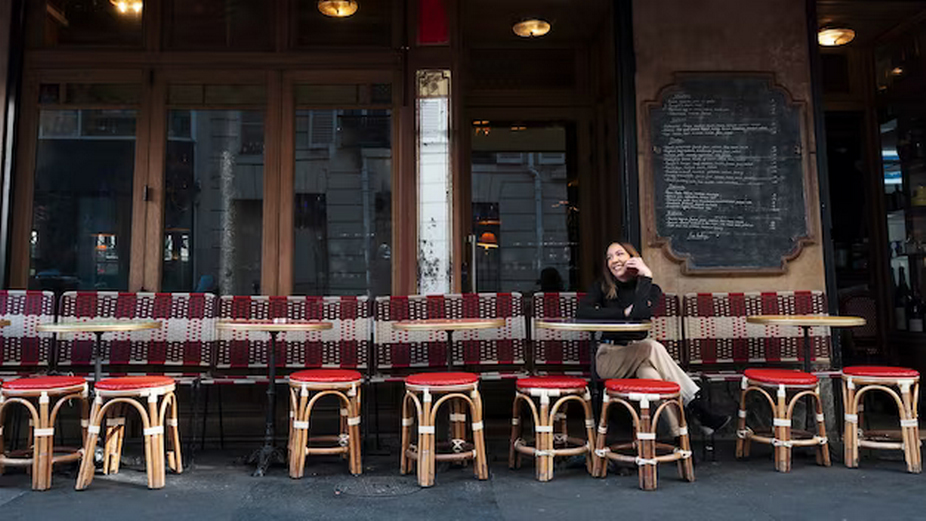 Girl sitting on the street near a bar