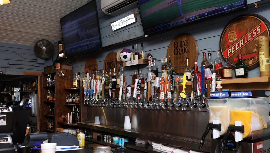 Bar counter with different drinks and TV screen